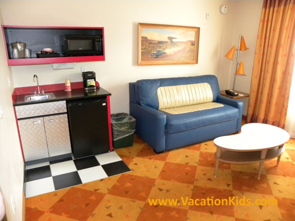 Main living area at Disney's Art of Animation Cars family suite offers a mini kitchenette and a double bed sleeper sofa