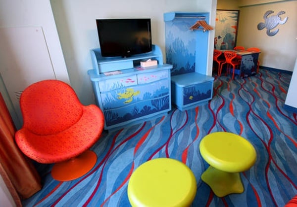 The main living area in Disney's Art of Animation Finding Nemo Suites offers a Flat screen TV, mini kitchenette and a dining table for 6 that converts to a double bed at night